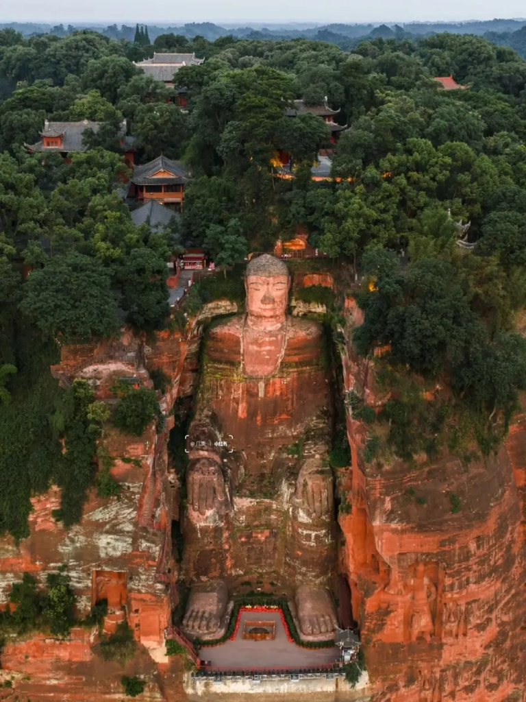 Full body view of the Leshan Giant Buddha carved into the cliff