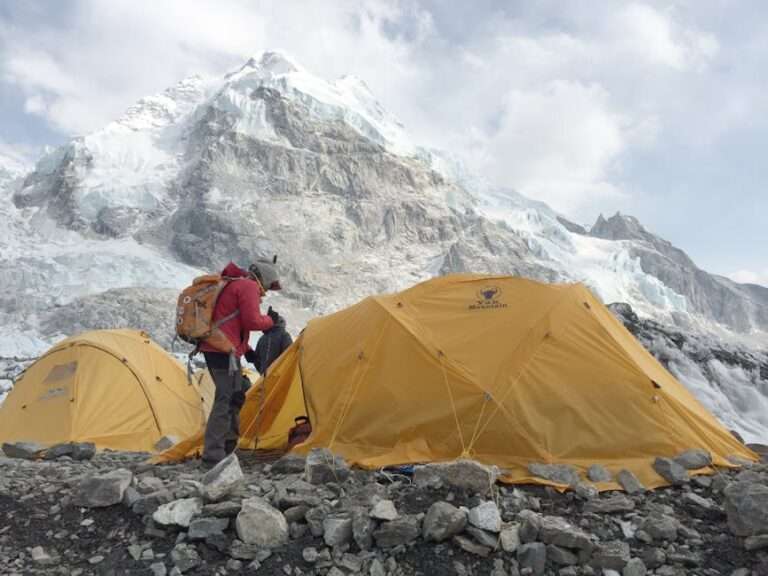 Yellow tents at Khumjung with majestic Himalayan peaks in the background, perfect for adventure travel
