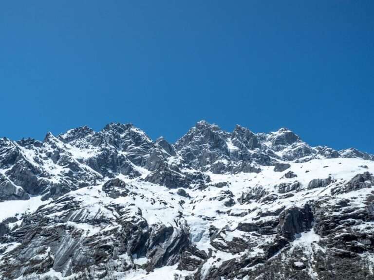 Majestic snow-covered mountains in Sichuan, China under a clear blue sky.