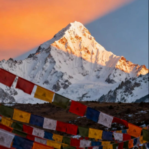 Tibetan prayer flags fluttering beneath snowy mountain peaks