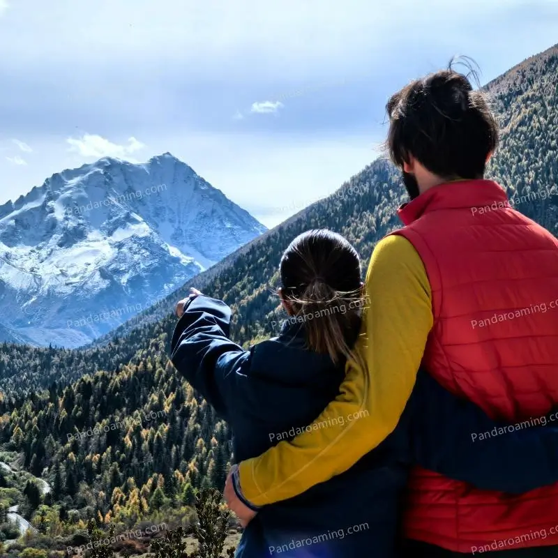 A couple looking at distant mountains during their Western Sichuan journey
