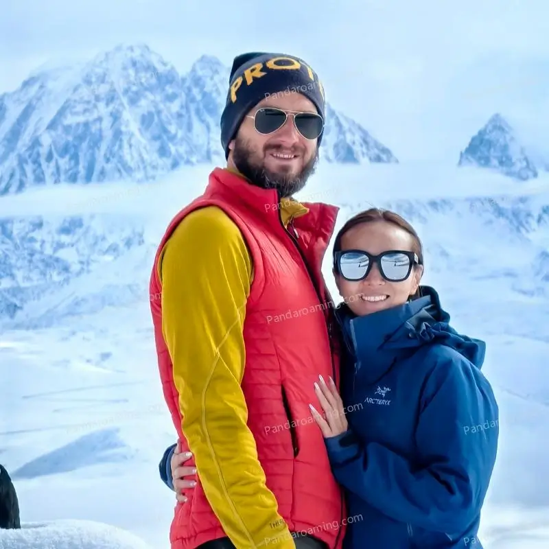 A couple taking photos together in front of a snowy mountain in Western Sichuan