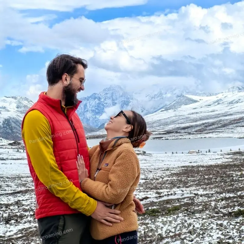 A couple stopping to enjoy snow mountains during a Western Sichuan tour