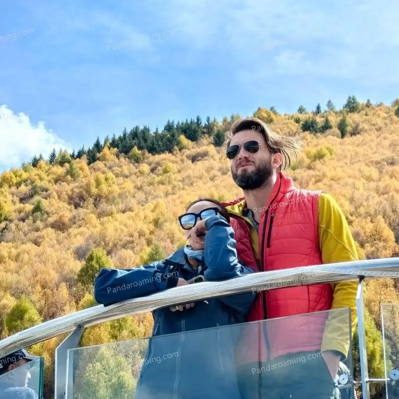 A couple relaxing at a roadside viewpoint with autumn forest in Western Sichuan