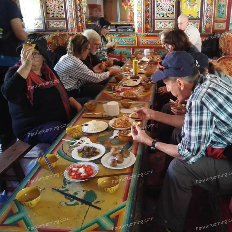 A group of travelers trying traditional Tibetan food during a cultural experience in Western Sichuan