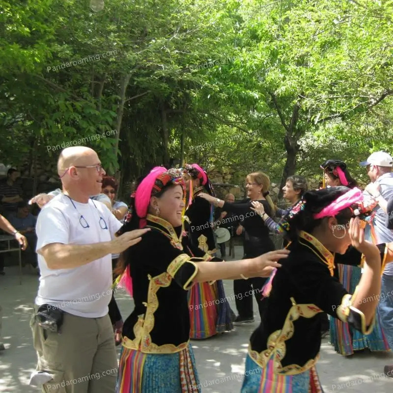 Travelers joining a circle dance with Yi ethnic locals during a cultural experience in Western China
