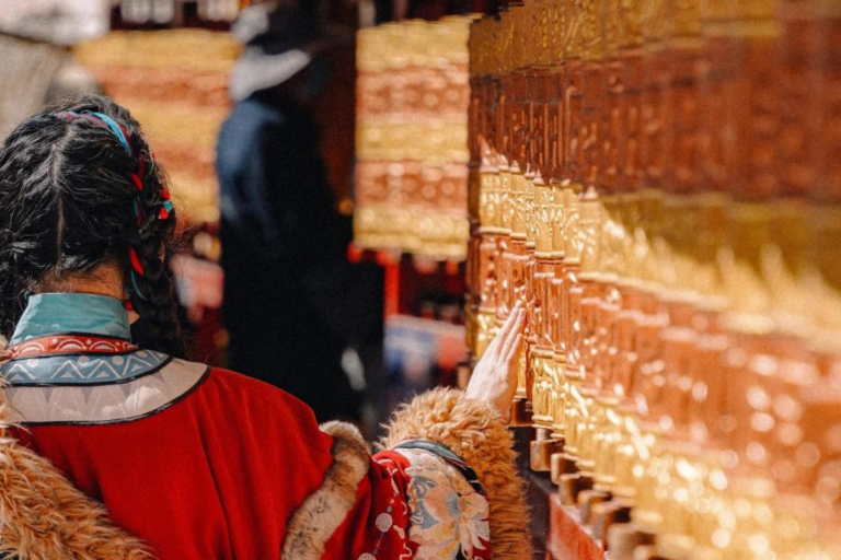 Tibetan pilgrims turning prayer wheels on Barkhor Street in Lhasa