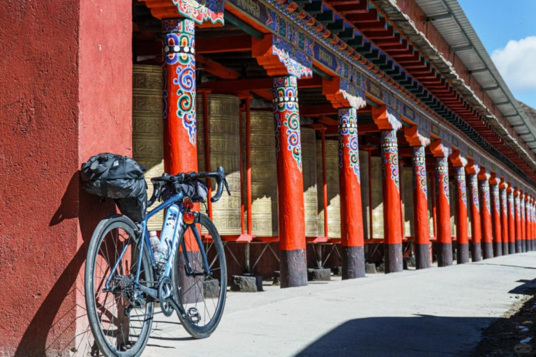 Bicycle parked beside a Tibetan prayer wheel in Western Sichuan