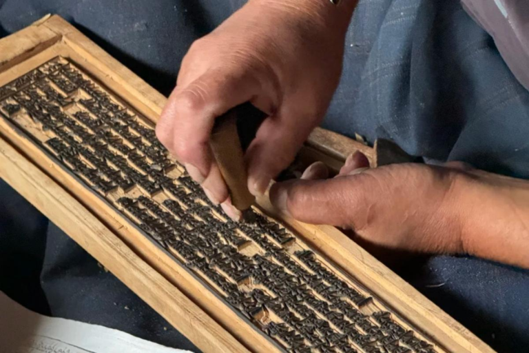 Artisan carving Tibetan Buddhist scriptures at Dege Printing House