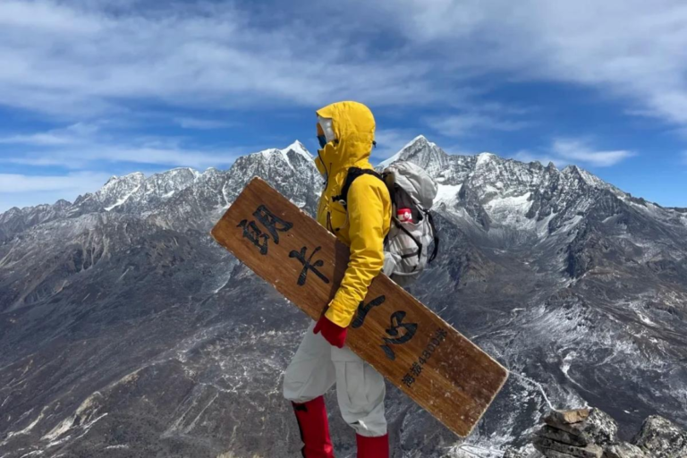 Hiker reaching the summit during the Langkaxin trekking route in Kangding, Sichuan