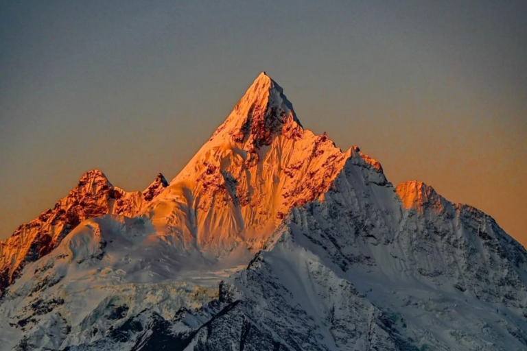 Golden sunlight shining on Meili Snow Mountain at sunrise