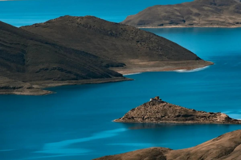 Turquoise waters of Yamdrok Lake surrounded by mountains in Tibet